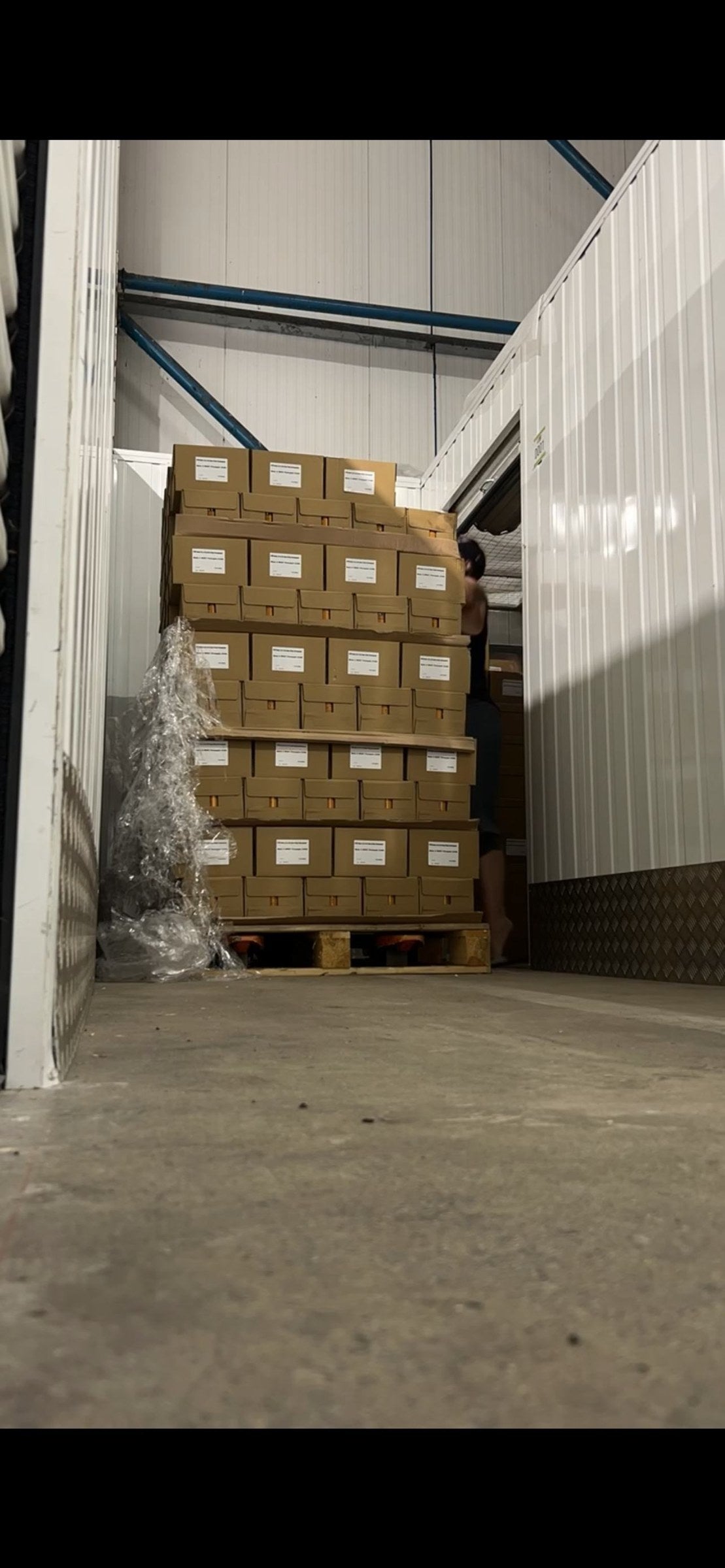 Boxes of Make It WHET stacked on a pallet inside storage
